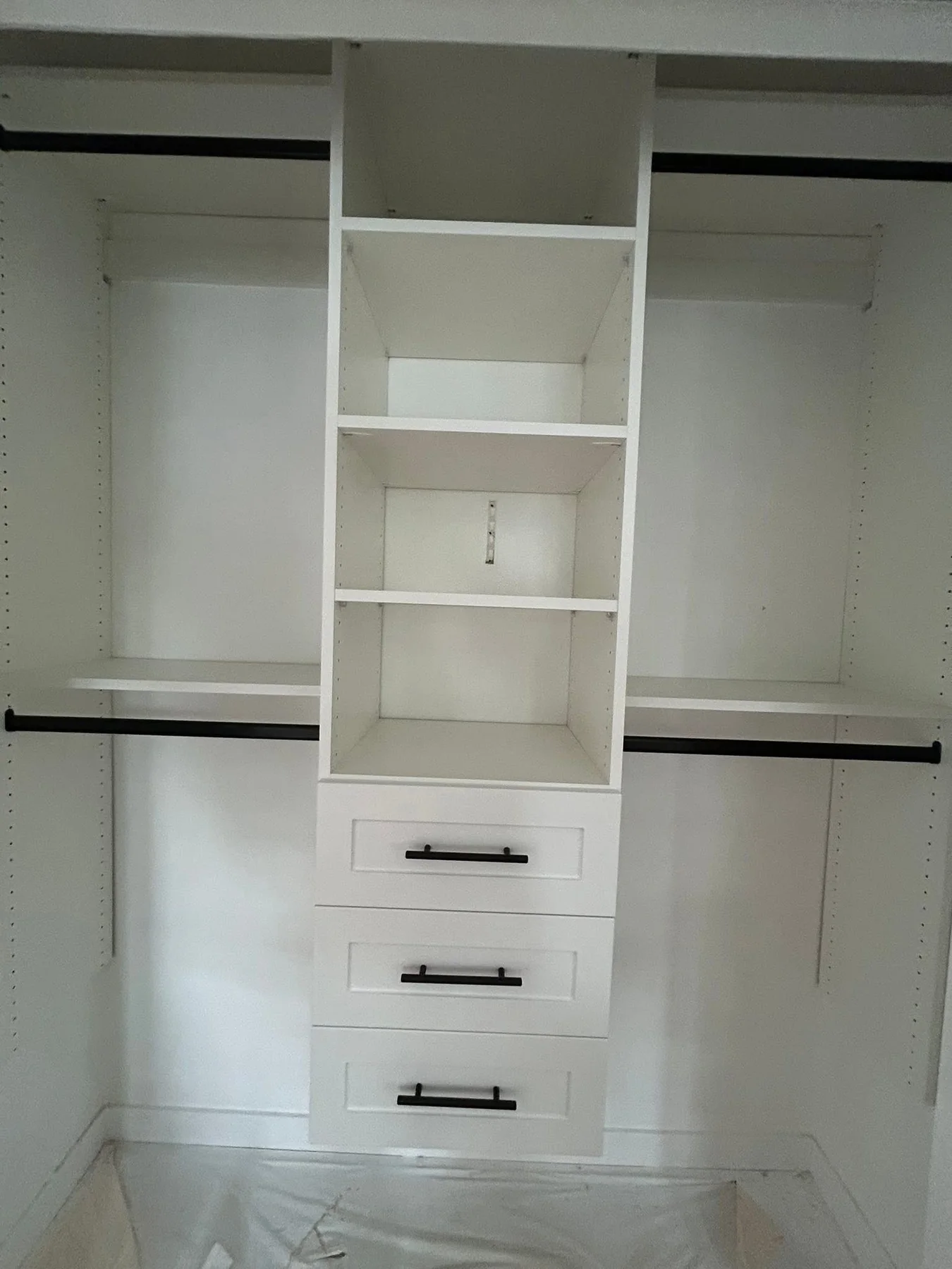 White custom closet with center drawers and black hardware